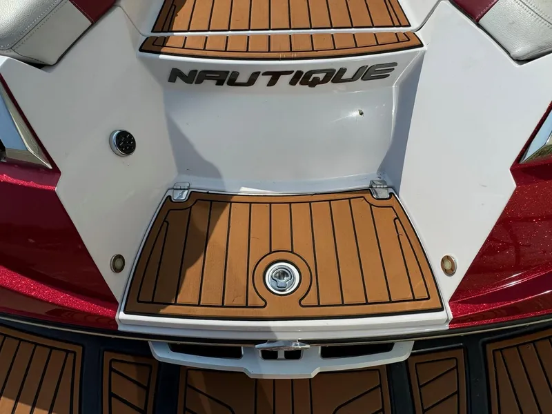 Slide: The Image of 2014 Nautique G23 boat deck with teak flooring and logo. - 9