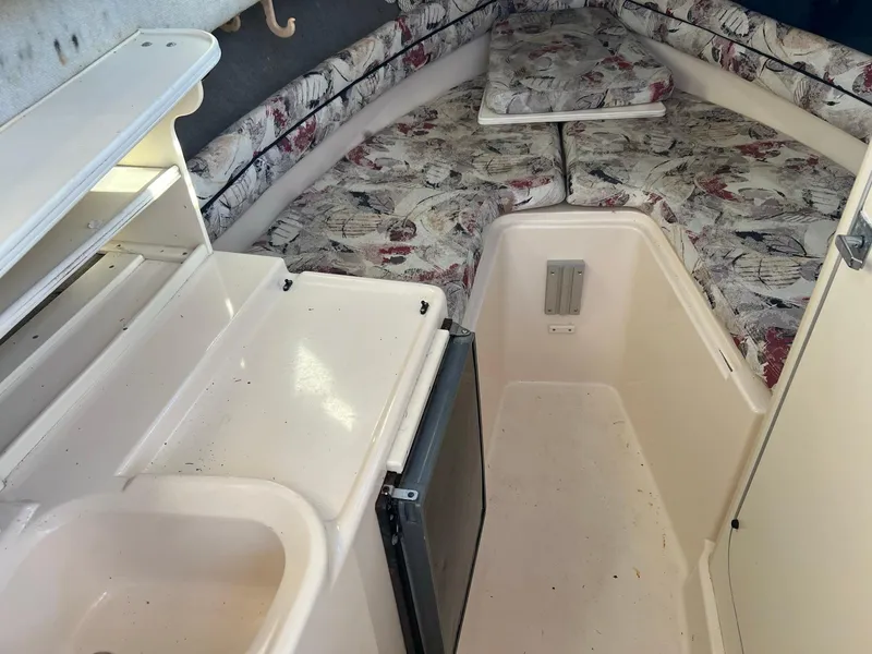 Slide: The Image of 1998 Grady-White Voyager 268 cabin interior with kitchenette and cushioned seating. - 10