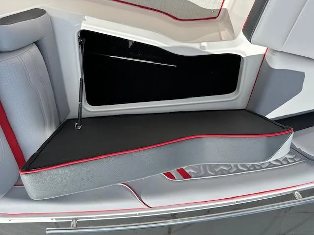 Slide: The Image of 2025 Regal LS4 boat interior storage compartment with cushioned seating. - 24