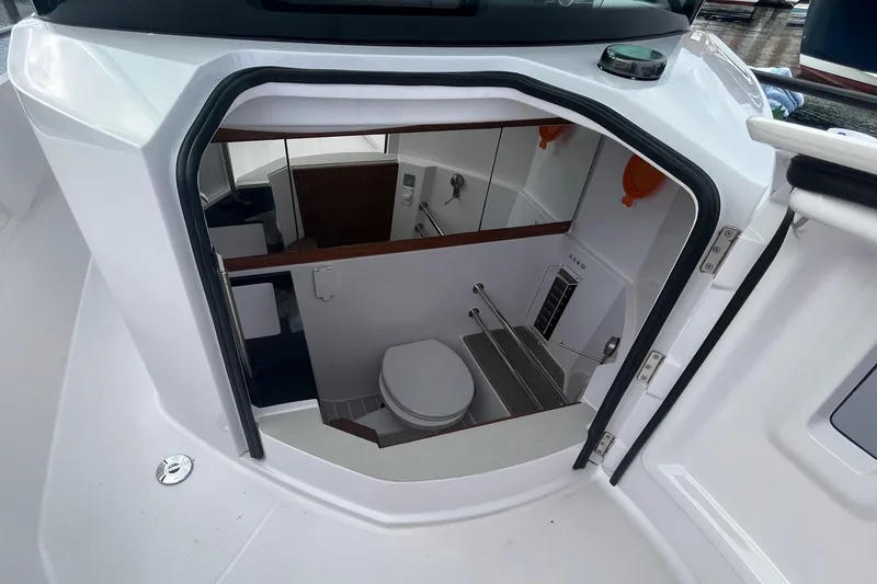 Slide: The Image of 2022 Axopar 28 CABIN boat interior with compact bathroom and toilet. - 11