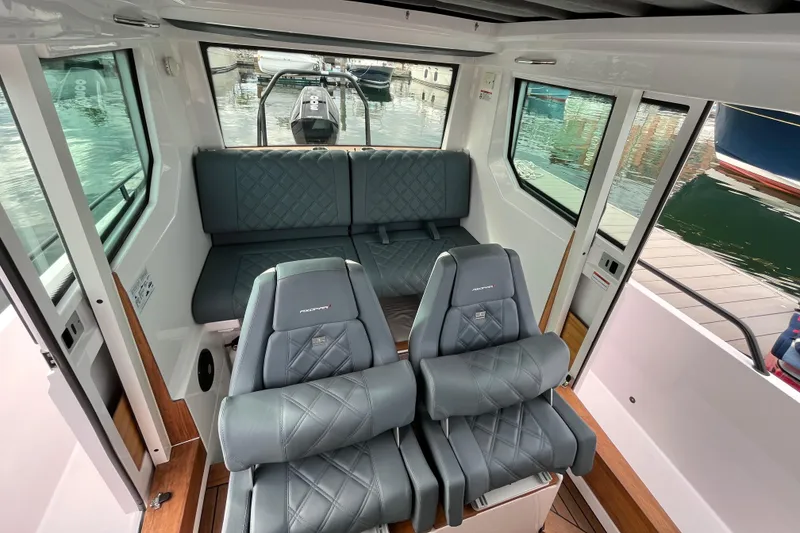 Slide: The Image of Interior of 2022 Axopar 28 CABIN with plush seating and panoramic windows. - 15