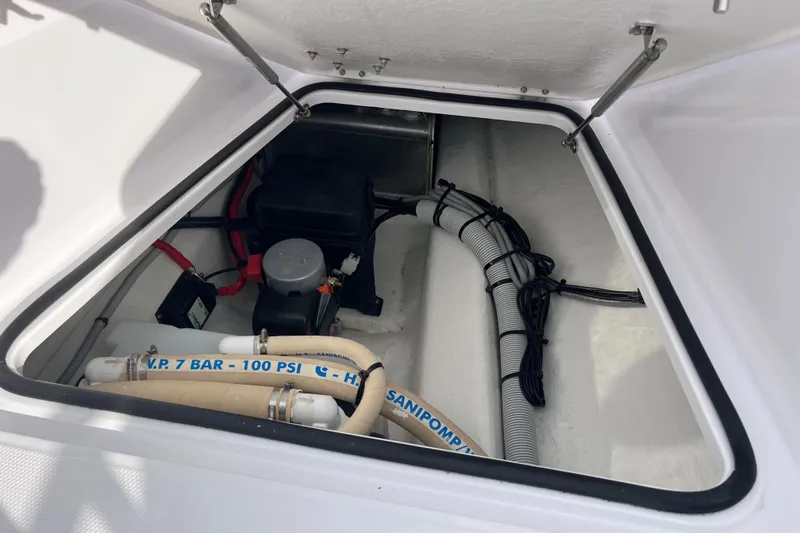 Slide: The Image of Axopar 28 CABIN 2022 boat storage compartment with hoses and equipment. - 24