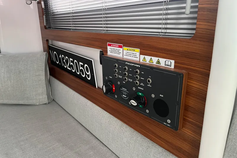Slide: The Image of Control panel of 2022 Axopar 28 CABIN with warning labels and registration number. - 29