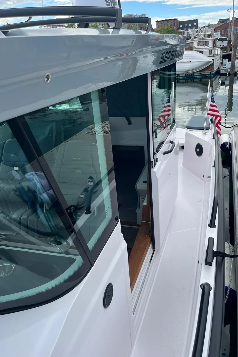 Slide: The Image of 2022 Axopar 28 CABIN boat docked with American flags. - 30