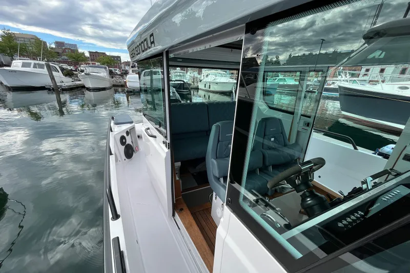 Slide: The Image of 2022 Axopar 28 CABIN boat docked in a marina, showcasing sleek design and modern features. - 31
