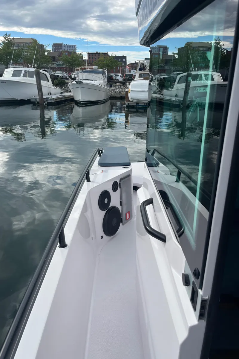 Slide: The Image of 2022 Axopar 28 CABIN boat docked in a marina with other vessels. - 32