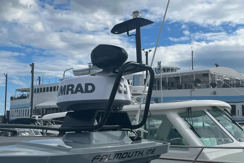 Slide: The Image of Axopar 28 CABIN 2022 boat with radar, docked in Falmouth, ME, under cloudy sky. - 37