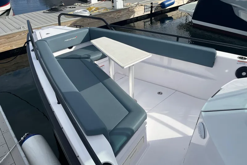 Slide: The Image of Axopar 28 CABIN 2022 boat interior with seating and table at dock. - 6