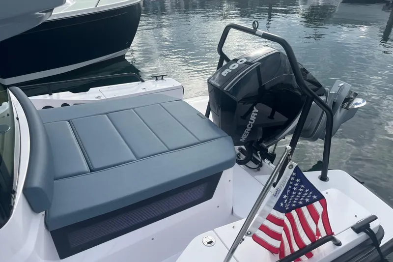 Slide: The Image of 2022 Axopar 28 CABIN boat with Mercury engine and American flag at marina. - 7