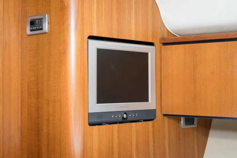 Slide: The Image of 2007 Tiara Yachts 4300 Sovran interior with wall-mounted TV and wooden cabinetry. - 41