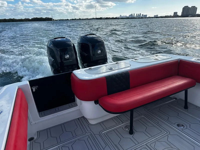 Slide: The Image of 2004 Contender 31 Tournament boat with red seating, dual engines, on open water. - 13