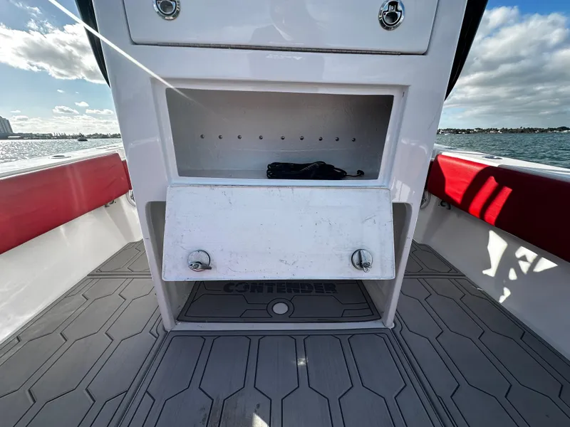 Slide: The Image of 2004 Contender 31 Tournament boat interior with storage compartment, red accents, and ocean view. - 16