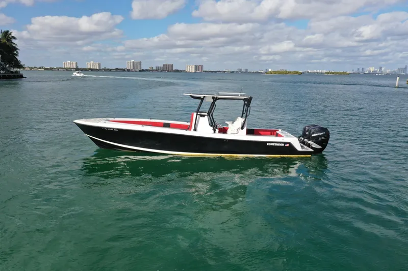 Slide: The Image of 2004 Contender 31 Tournament boat on calm water, city skyline in background. - 2