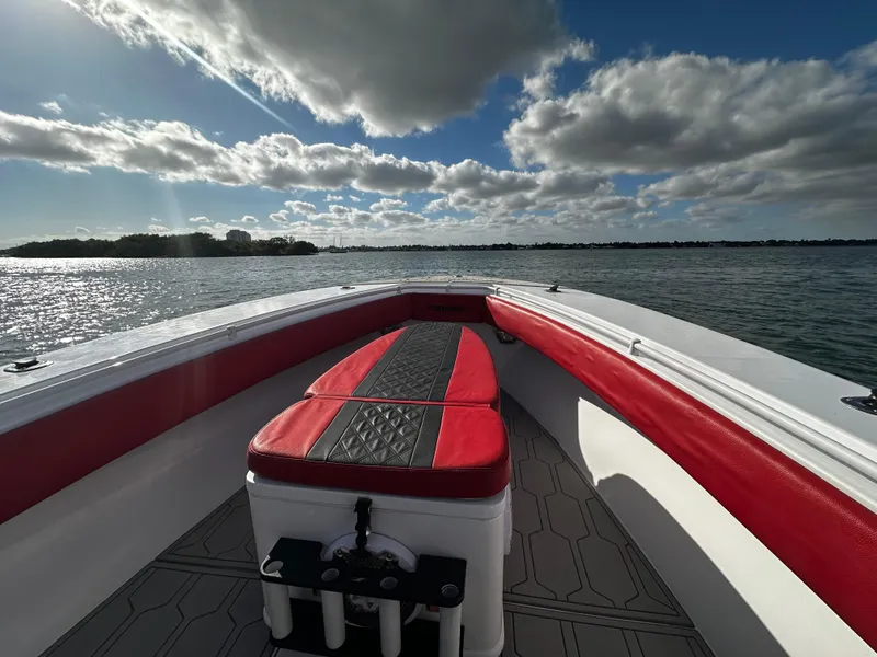 Slide: The Image of 2004 Contender 31 Tournament boat on water, red and white seating, sunny day. - 31