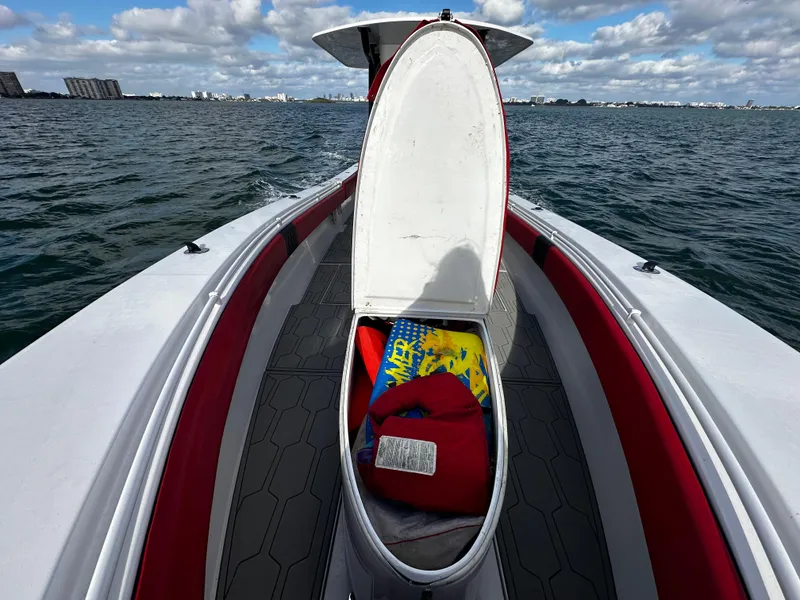 Slide: The Image of 2004 Contender 31 Tournament boat with open storage compartment on the water. - 32