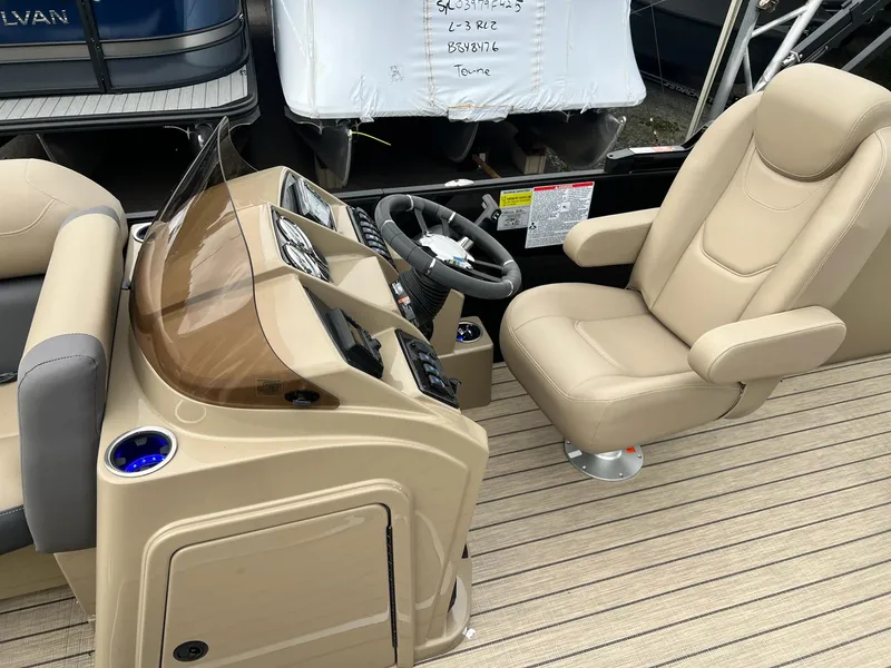 Slide: The Image of 2025 Sylvan X3 CLZ DH Mirage Tritoon helm with beige captain's chair and dashboard. - 12