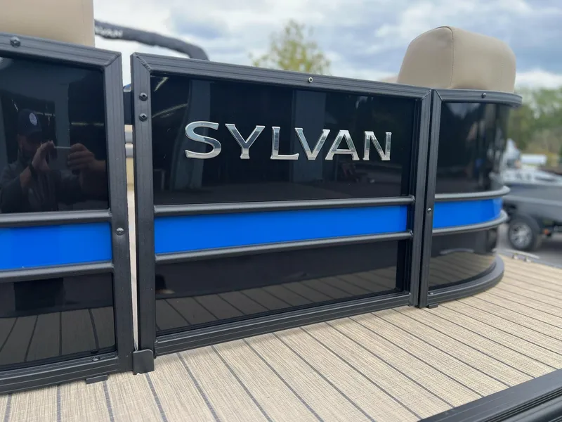 Slide: The Image of 2025 Sylvan X3 CLZ DH Mirage Tritoon boat with sleek black and blue design. - 14
