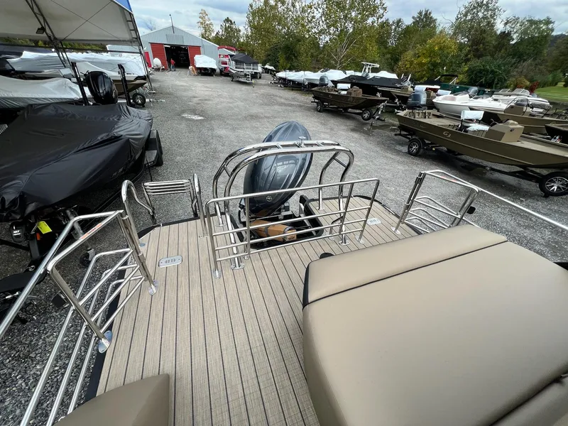 Slide: The Image of 2025 Sylvan X3 CLZ DH Mirage Tritoon in a boatyard, showcasing deck and seating. - 31