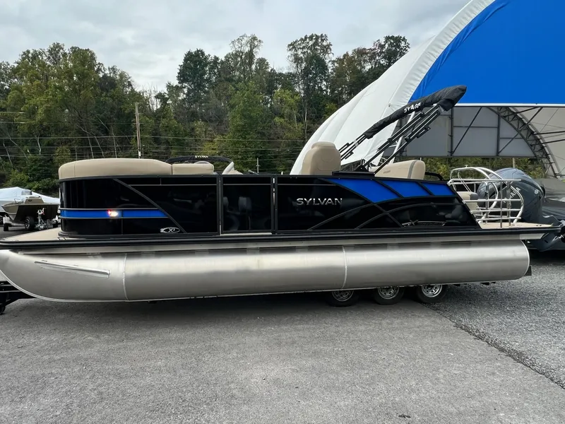 Slide: The Image of 2025 Sylvan X3 CLZ DH Mirage Tritoon boat parked outdoors. - 33