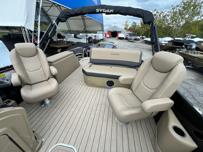 Slide: The Image of 2025 Sylvan X3 CLZ DH Mirage Tritoon interior with beige seating and spacious deck. - 5