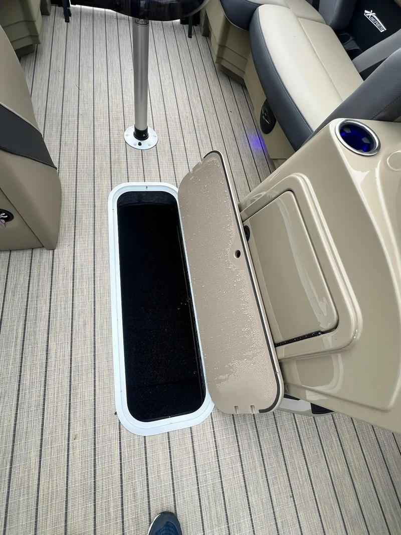Slide: The Image of 2025 Sylvan X3 CLZ DH Mirage Tritoon interior with open storage compartment. - 8
