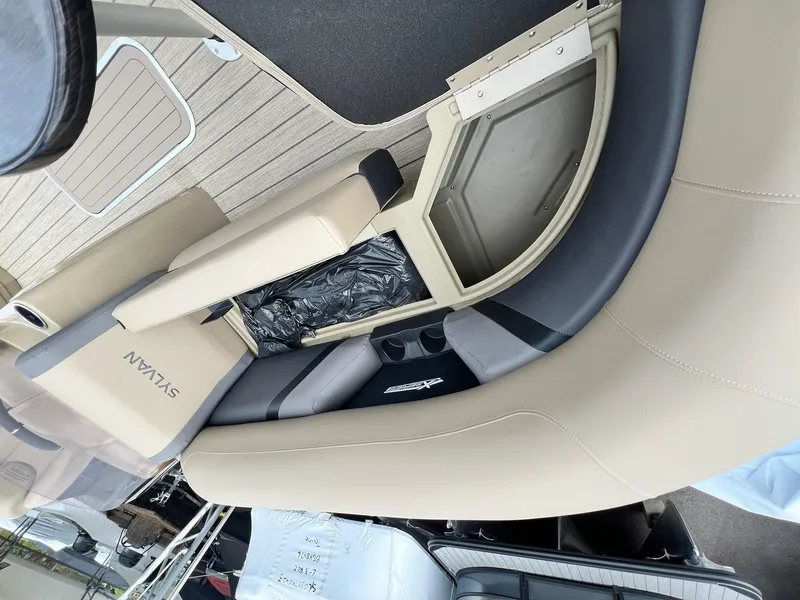Slide: The Image of 2025 Sylvan X3 CLZ DH Mirage Tritoon interior seating with storage compartment. - 9