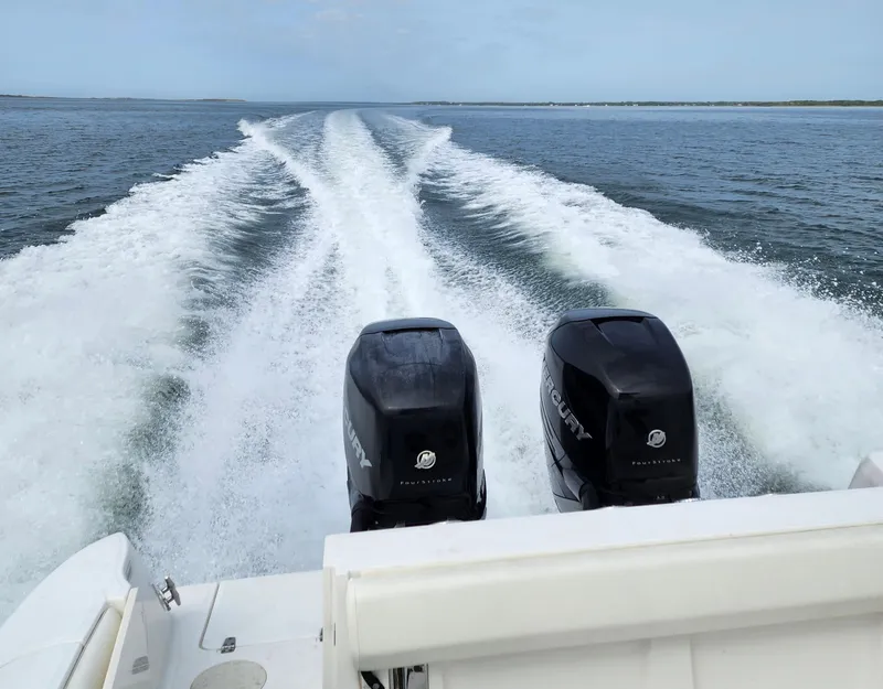 Slide: The Image of Boston Whaler 320 Outrage 2010 with twin Mercury engines cruising on open water. - 11