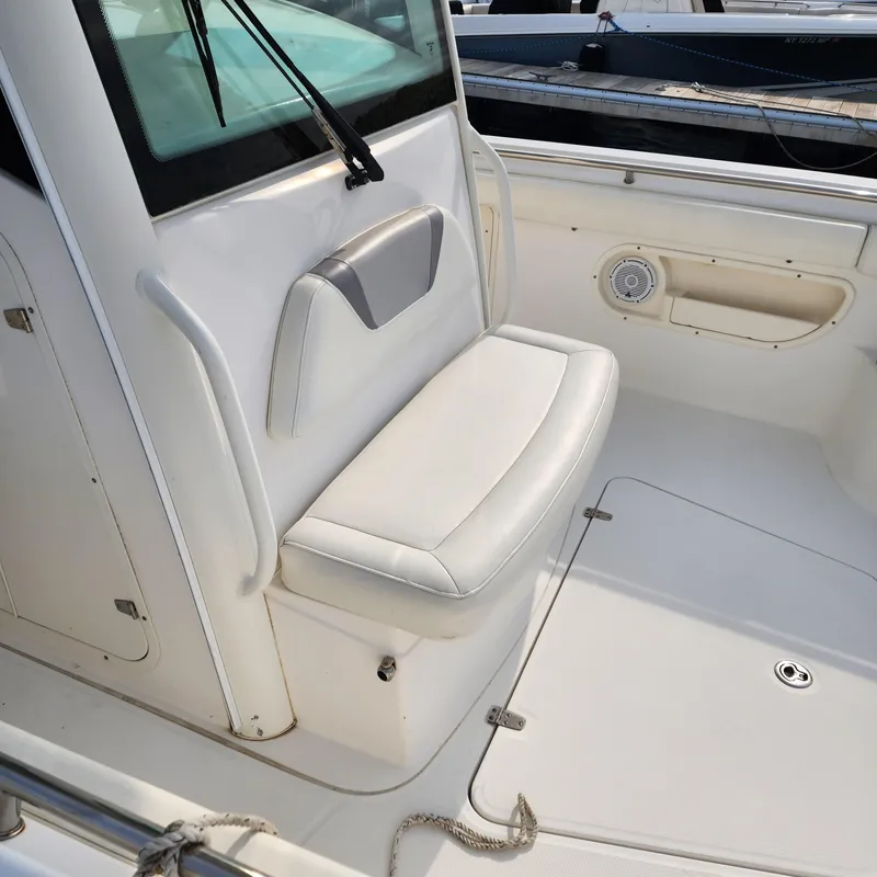 Slide: The Image of 2010 Boston Whaler 320 Outrage boat interior with white seating and storage. - 9