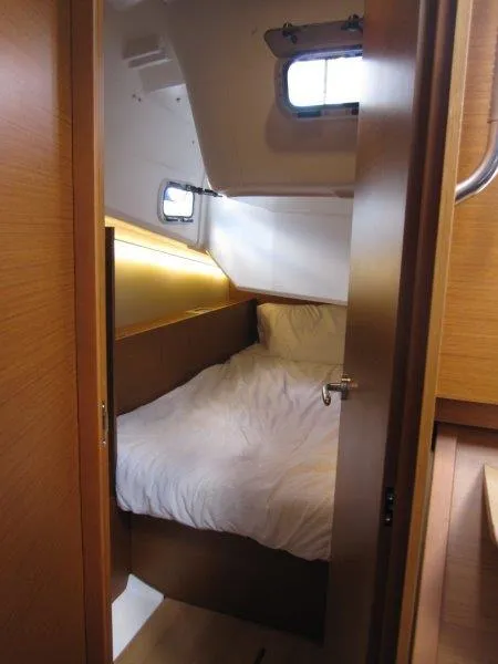 Slide: The Image of Cozy cabin interior of 2025 Jeanneau 380 sailboat with bed and porthole windows. - 16
