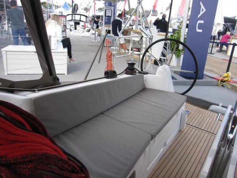 Slide: The Image of 2025 Jeanneau 380 sailboat cockpit with cushioned seating at a boat show. - 19