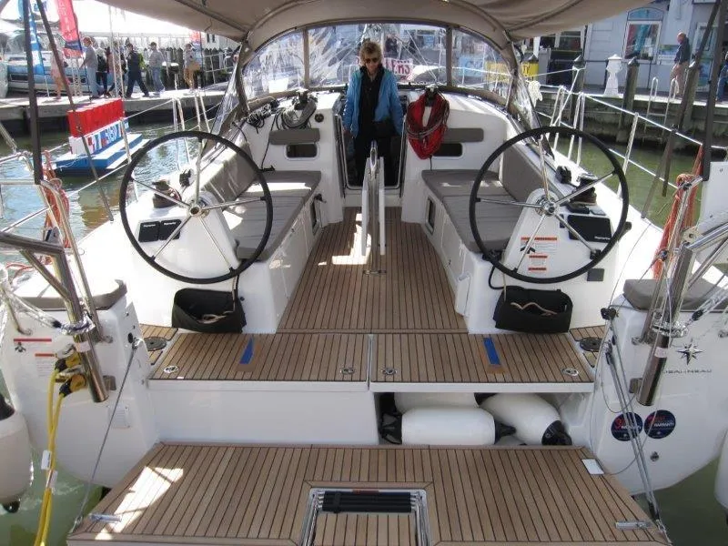 Slide: The Image of 2025 Jeanneau 380 sailboat cockpit with dual steering wheels and teak decking. - 20