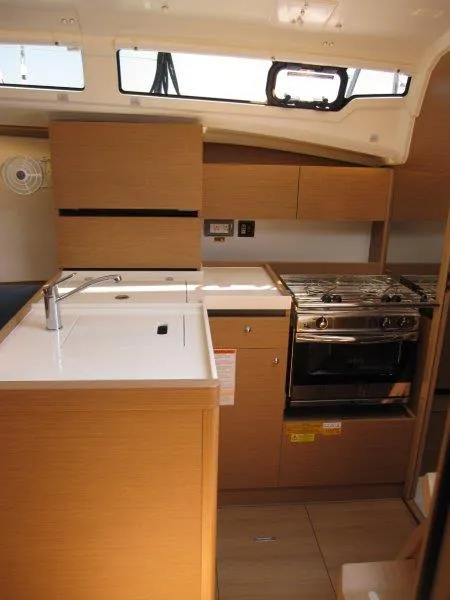 Slide: The Image of 2025 Jeanneau Sun Odyssey 350 yacht kitchen with modern appliances and wood cabinetry. - 11