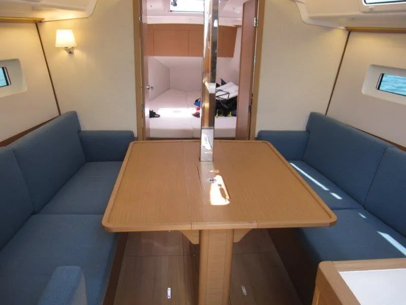 Slide: The Image of 2025 Jeanneau Sun Odyssey 350 interior with cozy seating and wooden dining table. - 30