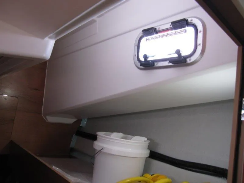Slide: The Image of Interior of 2025 Jeanneau Sun Odyssey 350 sailboat with porthole and storage area. - 19