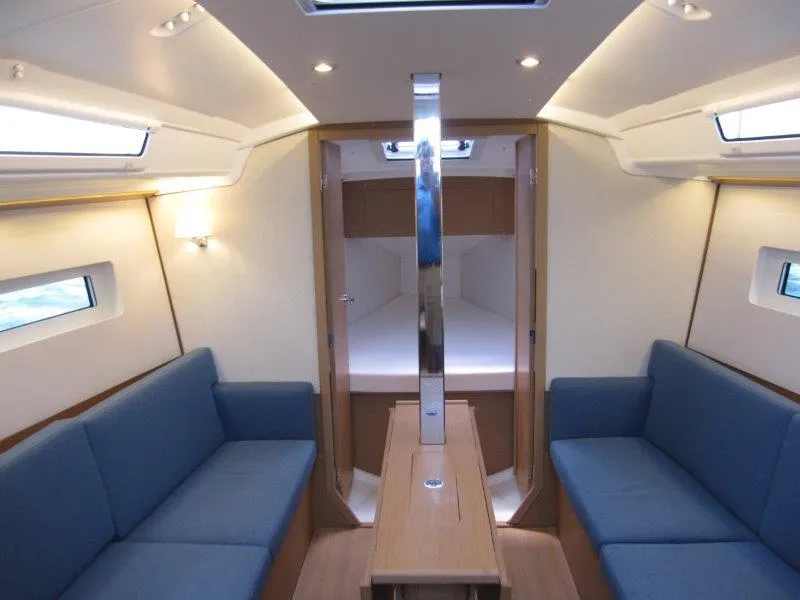 Slide: The Image of Interior of 2025 Jeanneau Sun Odyssey 350 sailboat with blue seating and modern design. - 1