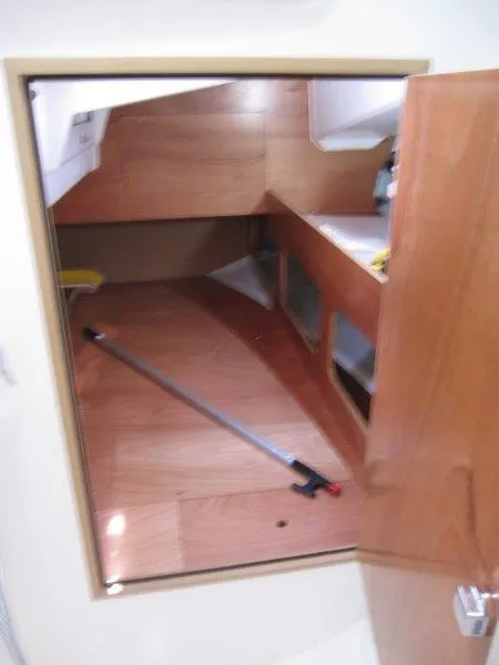 Slide: The Image of Interior cabin of 2025 Jeanneau Sun Odyssey 350 sailboat, featuring wooden finishes and storage space. - 17