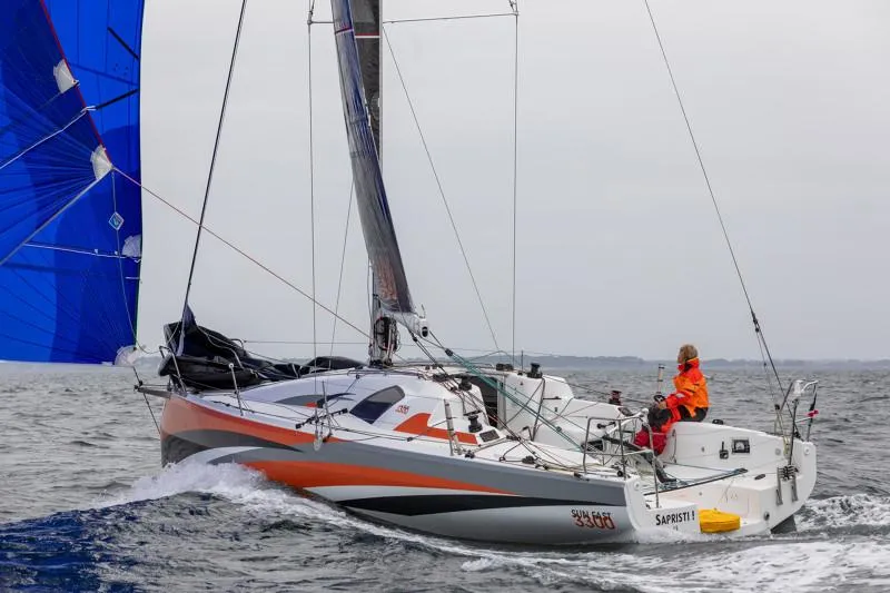 Slide: The Image of 2025 Jeanneau Sun Fast 3300 sailing on open water with vibrant blue sail. - 35