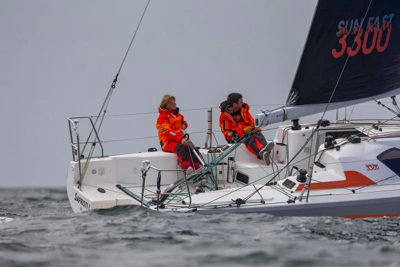 Slide: The Image of 2025 Jeanneau Sun Fast 3300 sailing with crew in orange jackets on open water. - 29