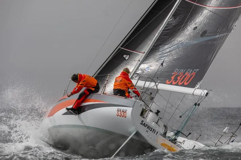 Slide: The Image of 2025 Jeanneau Sun Fast 3300 sailing in rough seas, crew in orange jackets. - 49