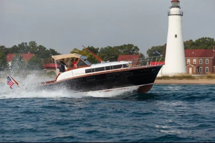 Slide: The Image of 1957 Chris-Craft 33 Futura cruising near a lighthouse on a sunny day. - 2