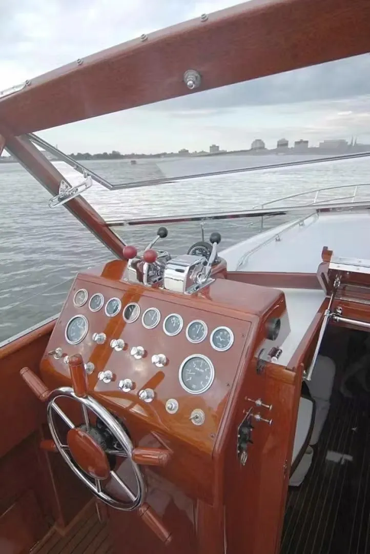 Slide: The Image of 1957 Chris-Craft 33 Futura boat dashboard with classic wooden steering wheel and gauges. - 23