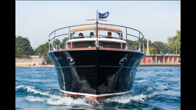 Slide: The Image of 1957 Chris-Craft 33 Futura cruising on water, front view with flag. - 3