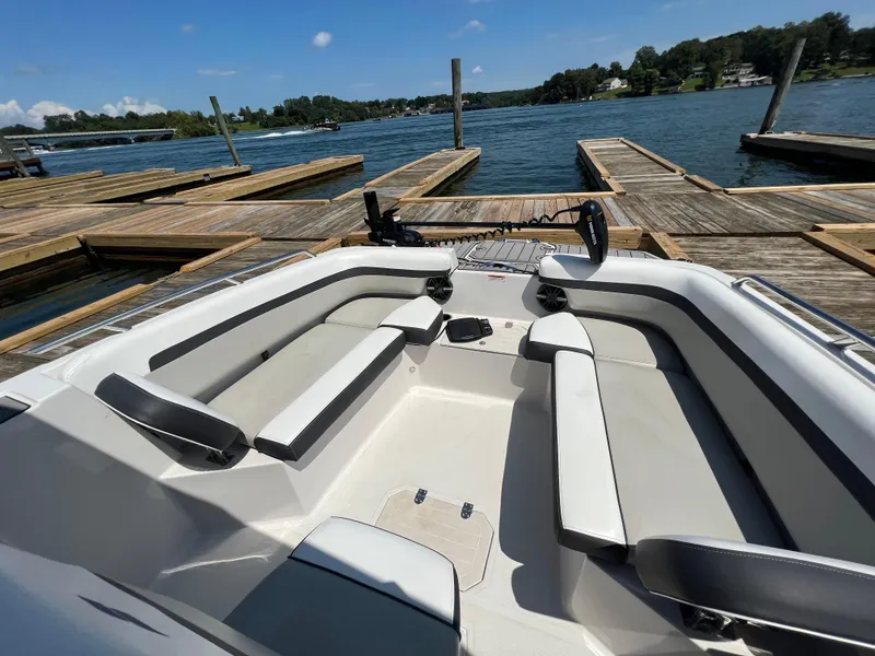 Slide: The Image of 2024 Starcraft SVX 211 OB CC boat interior at dock, featuring spacious seating. - 5