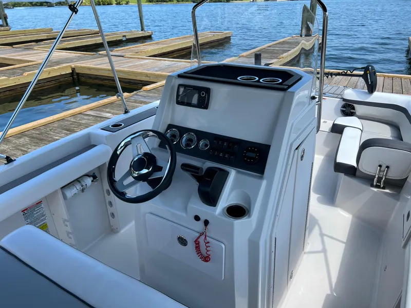 Slide: The Image of 2024 Starcraft SVX 211 OB CC boat interior with steering wheel and control panel. - 9