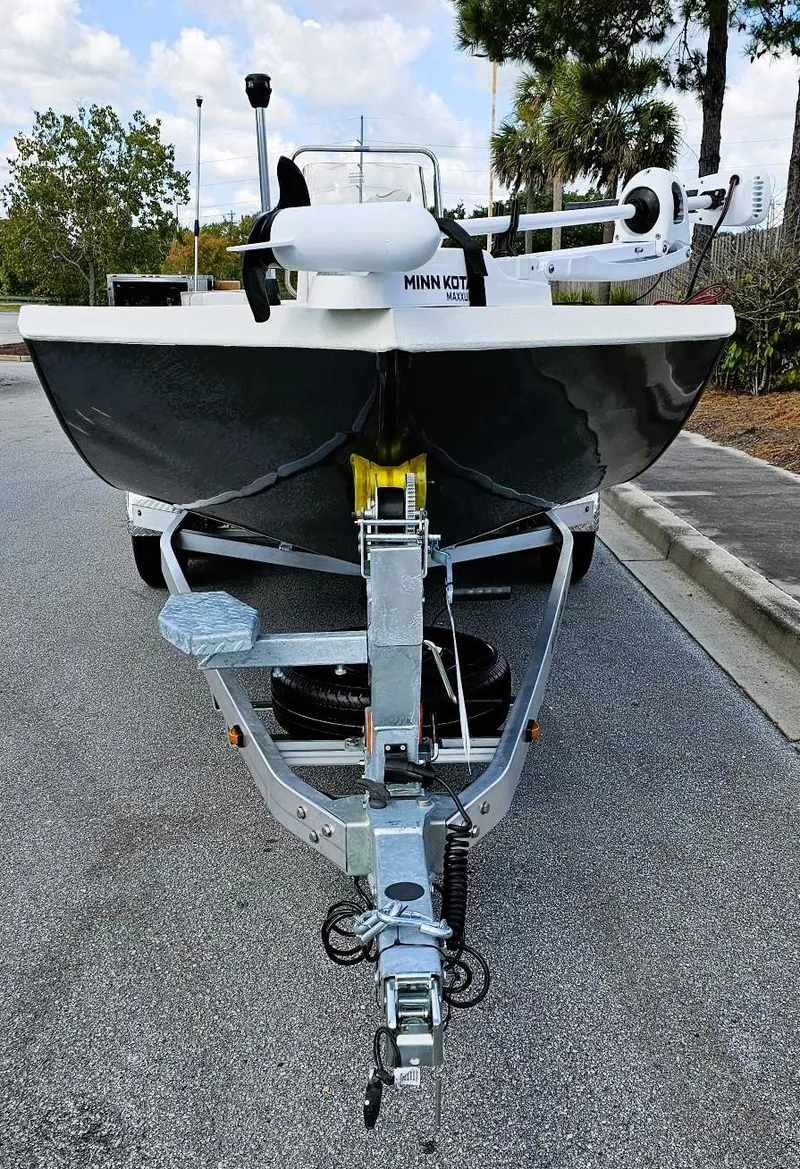 Slide: The Image of 2024 Ranger RB200 boat on trailer, parked on road, with trees in background. - 5