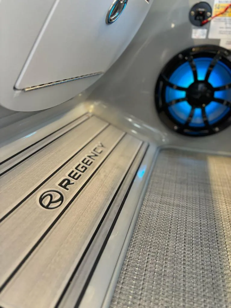 Slide: The Image of 2024 Regency 250 LE3 boat interior with branded flooring and speaker. - 10
