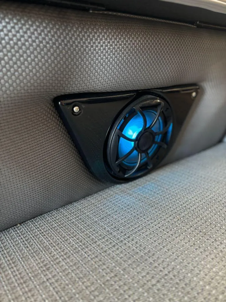 Slide: The Image of 2024 Regency 250 LE3 boat speaker with blue LED light on textured surface. - 11