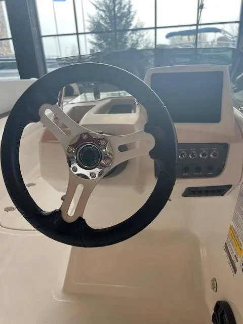 Slide: The Image of 2024 Tahoe T18 boat steering wheel and dashboard with modern controls. - 6