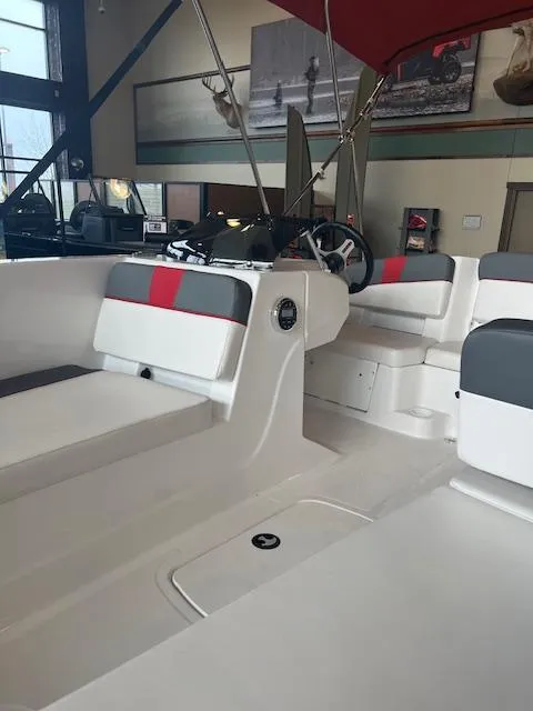 Slide: The Image of 2024 Tahoe T18 boat interior with modern seating and steering wheel in showroom. - 7