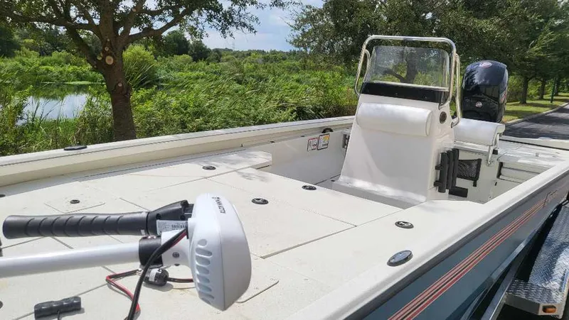 Slide: The Image of 2024 Ranger RB200 boat with trolling motor, parked near lush greenery. - 3